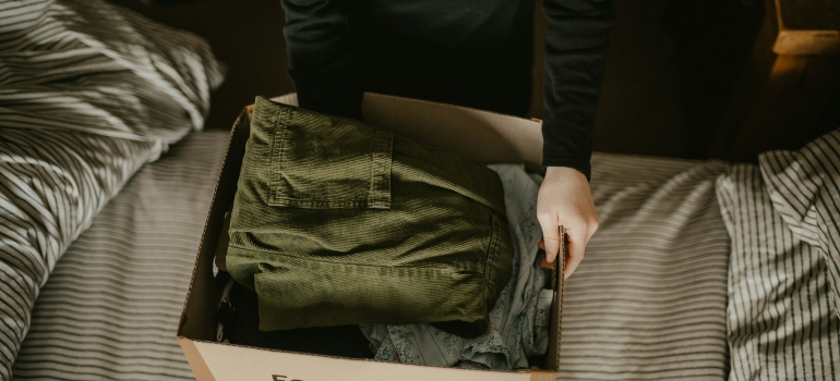 A person packing clothes after they had to look for temperature-controlled storage