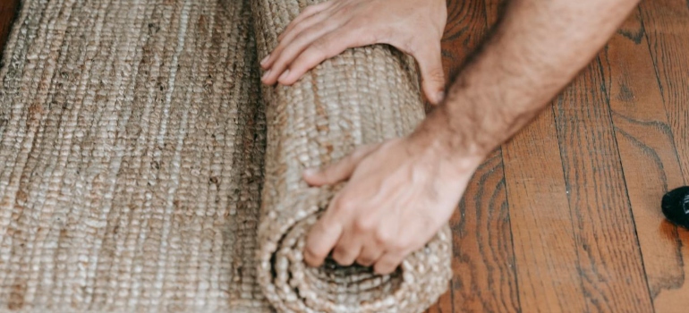 A person rolling a carpet