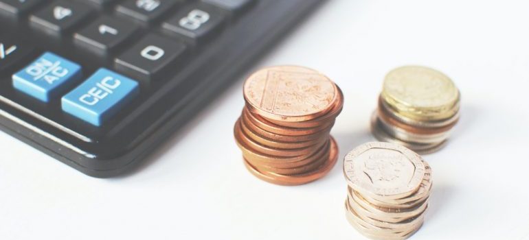 calculator surrounded with coins