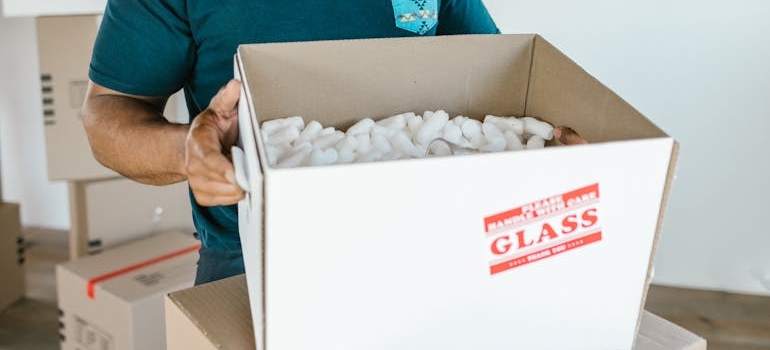 A man packing glass items for storage