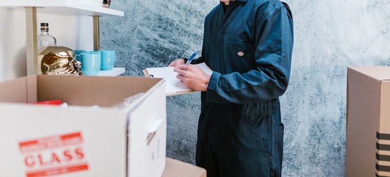 A man inventorying a box labeled Glass