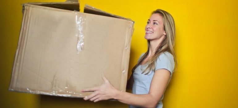 Woman carrying a damaged cardboard box