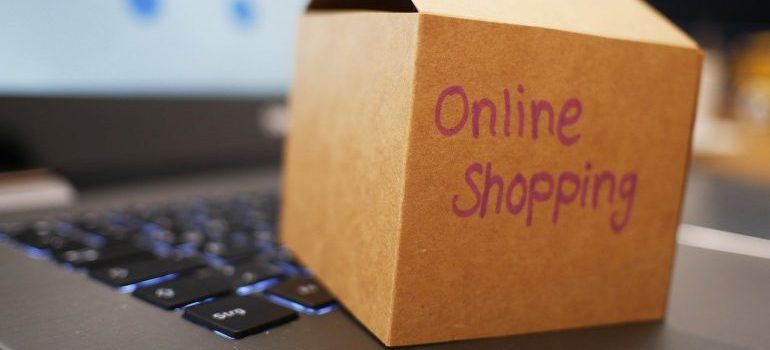 Online shopping written on a box next to a laptop