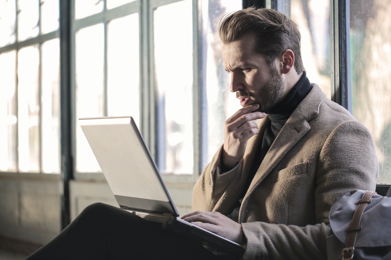 Man reading on his laptop about reasons why people rent self storage
