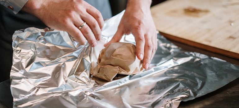 A person packing porcelain figurines on a table