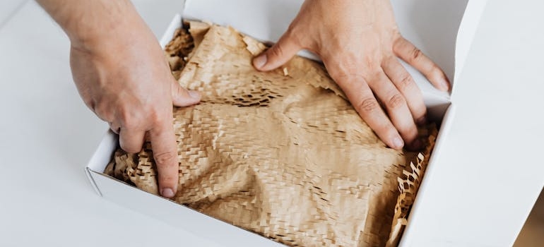 A person filling space in a box with paper