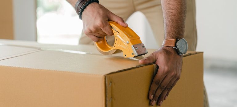 Person taping a box closed.