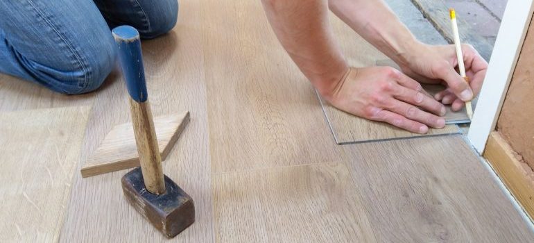 Man repairing flooring after reading about the reasons why people rent self storage
