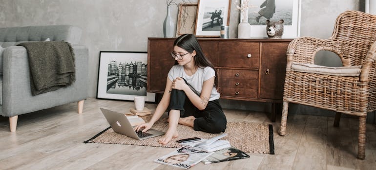 Smiling young woman using laptop at home because her self storage helps self-discipline