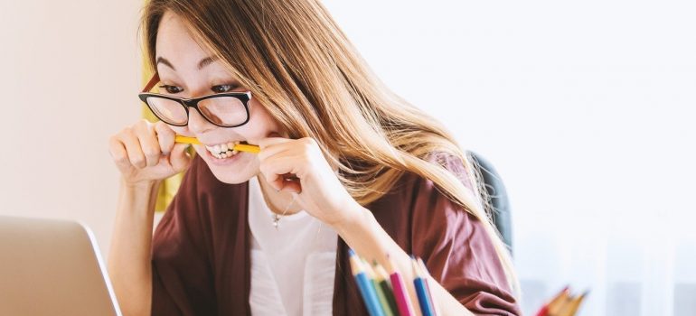 A girl chewing a pencil and reading how to speed up relocation with storage solutions.