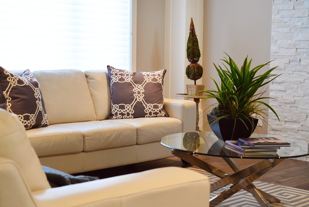 A room with furniture before storing couches and armchairs