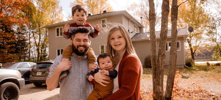 A family in front of a house after renting storage during the pandemic.