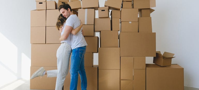Man and woman hugging near the pile of boxes