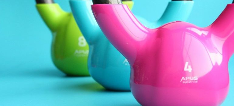 Colorful kettlebells on a blue floor.