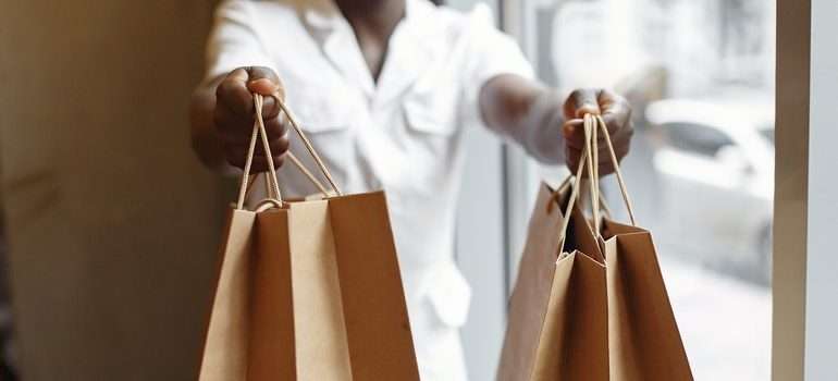 Person holding out shopping bags.