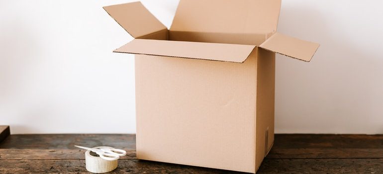 Cardboard box and tape on a desk.