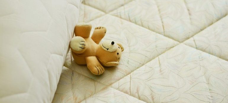 A teddy bear on the mattress.