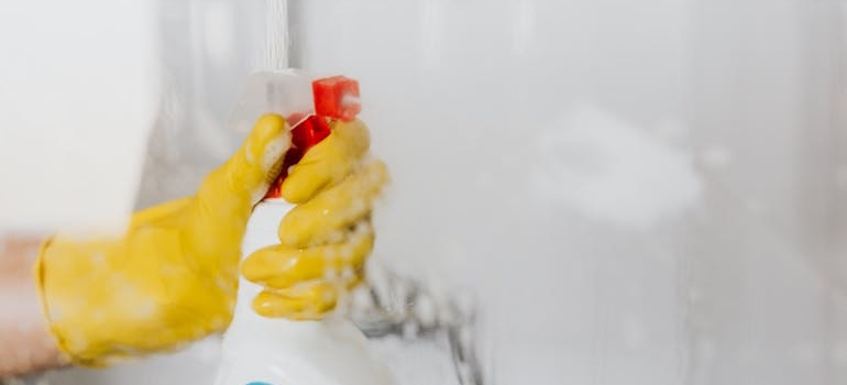 A person in cleaning gloves spraying