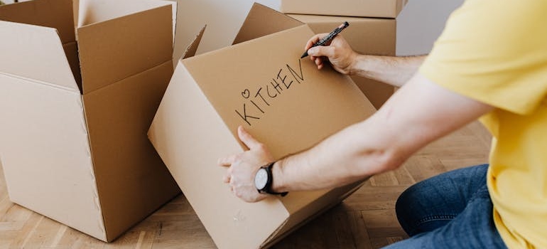 A man shows how to label and pack kitchen appliances for storage