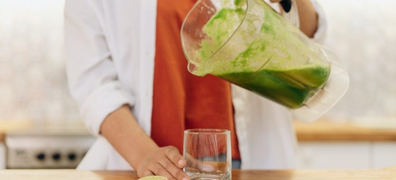 Person pouring juice from a blender. 