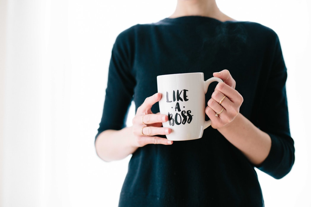 Person in one of the occupations that benefit most from self storage holding a mug that says