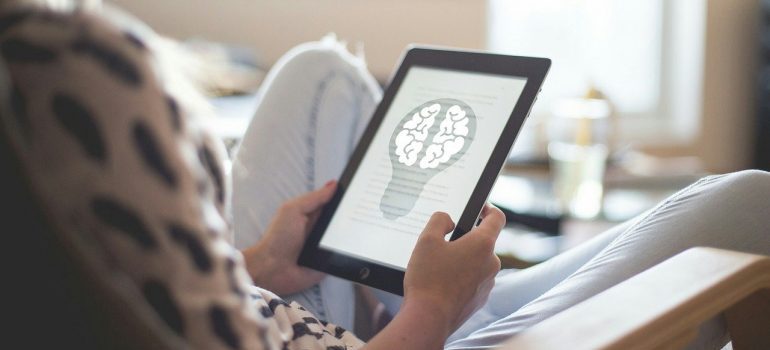 A woman reading a text on a tablet. 