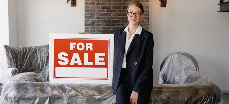 A real estate agent with a sale sign in a living room