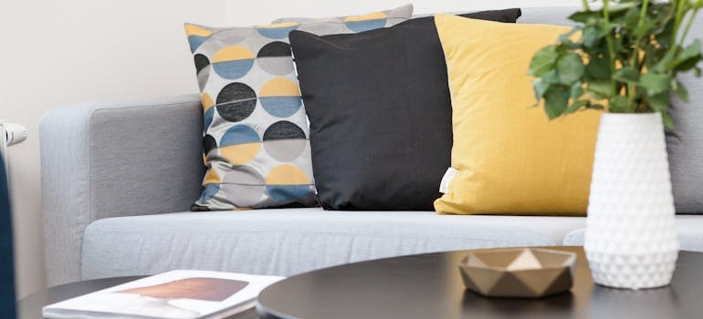 Centerpiece on coffee table beside sofa with three pillows
