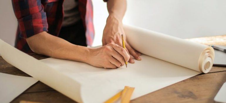 man writing on hammer paper