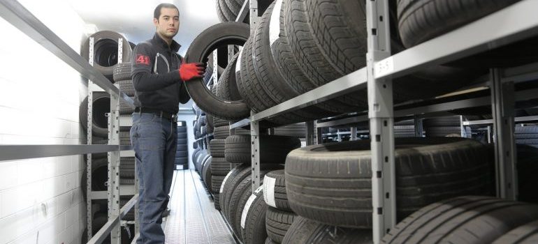A worker storing tires long-term.