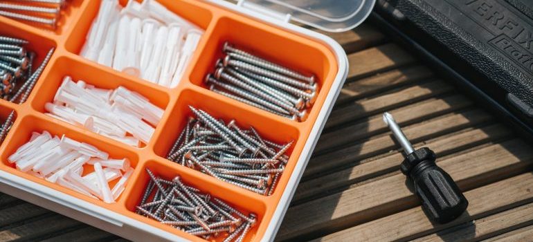 Screws and bolts organized in a plastic box.