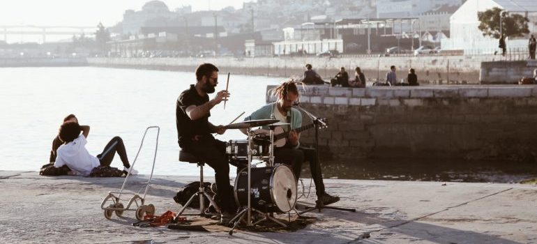 Two guys playing on the pier before storing musical instruments safely