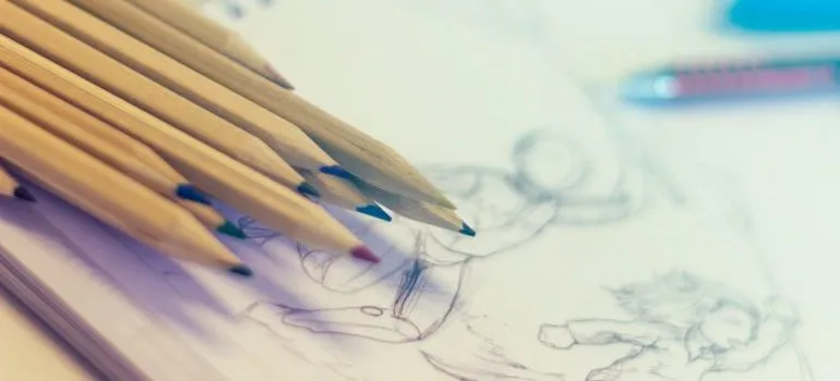 Several pencils resting on a sketch.