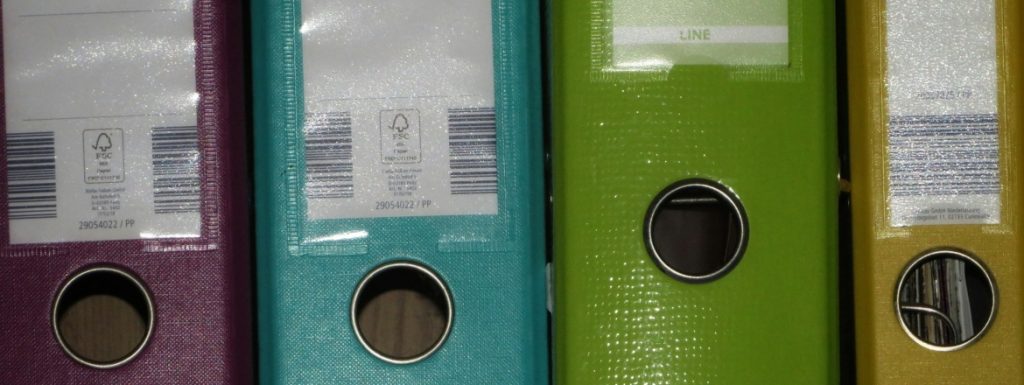 A row of colored binders on a shelf