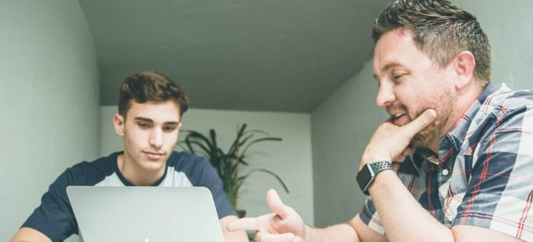 two people looking at a laptop