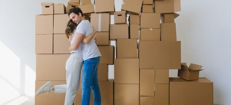 a couple hugging infant boxes