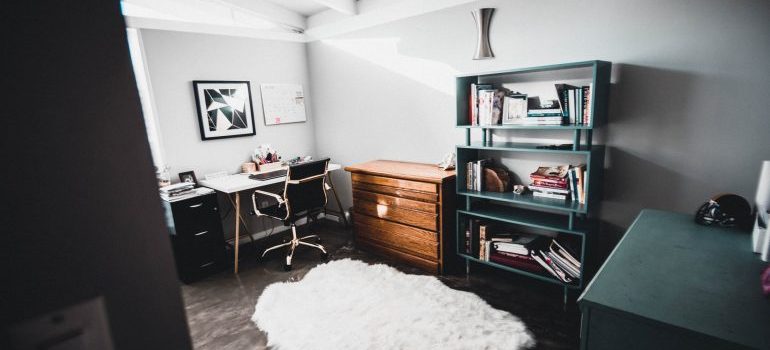 home office with a white carpet and shelves