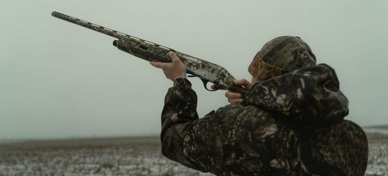 A man is aiming a rifle