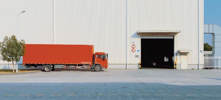 red truck parked in front of a warehouse