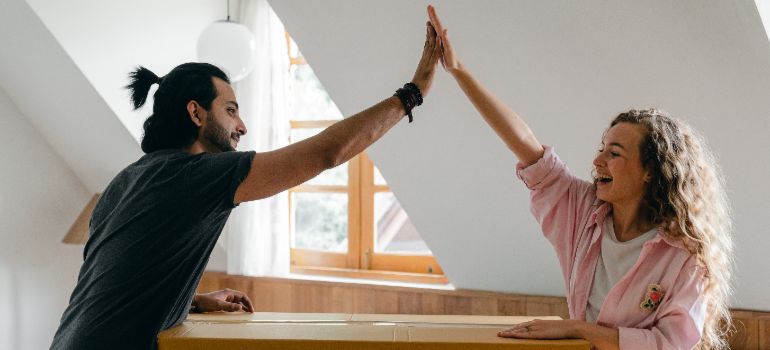 man and woman high fiving agreeing that portable storage is perfect for small-scale moves