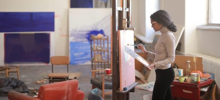 a woman painting while using the benefits of self storage for artisans