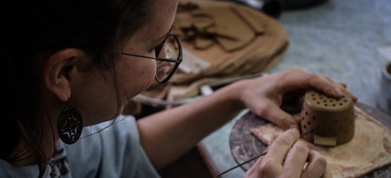 woman making an object out of clay