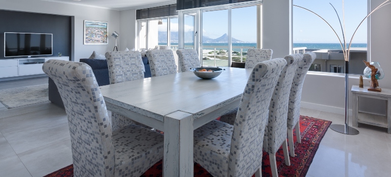 A white wooden table with chairs around it.