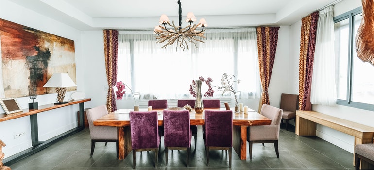 A dining room table in a big bright room.