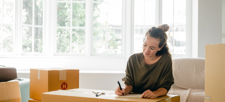 Woman labeling boxes and avoiding self storage mistakes students make
