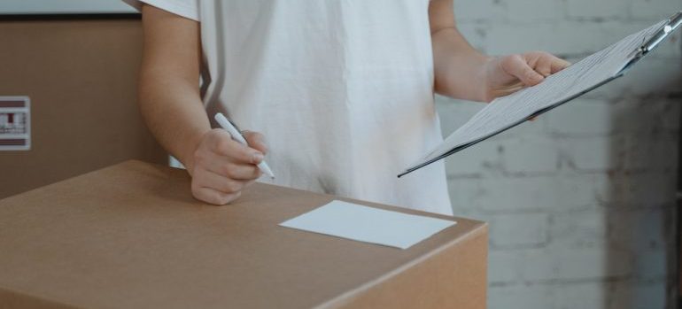 woman making a list before unpackig self storage container