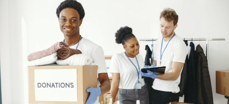 people carrying boxes for donation