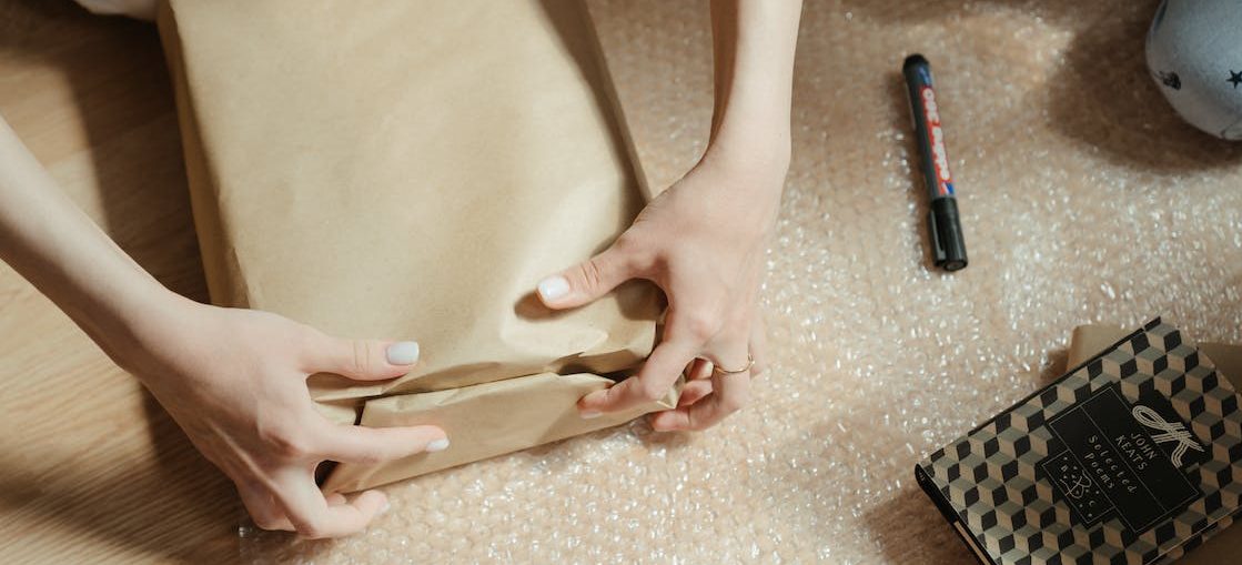 A woman wrapping a parcel while packing up your WA workshop for storage