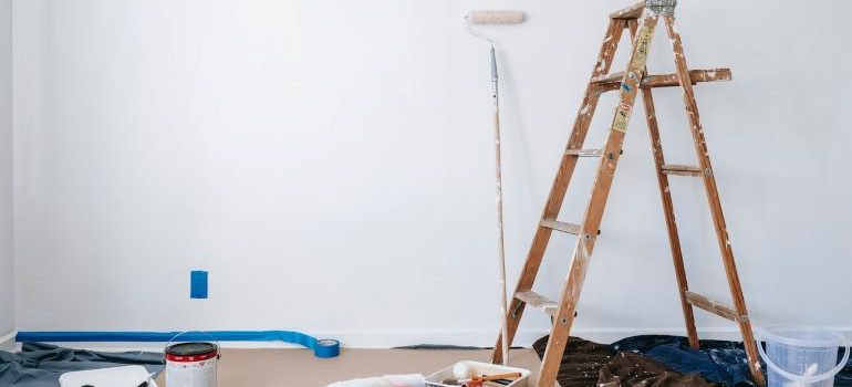 brown ladders standing next to the painting materials