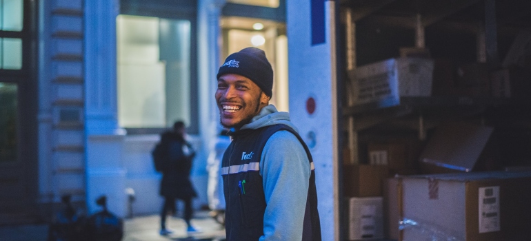 A man next to a moving truck is happy because Seattle self storage makes DIY moving easier